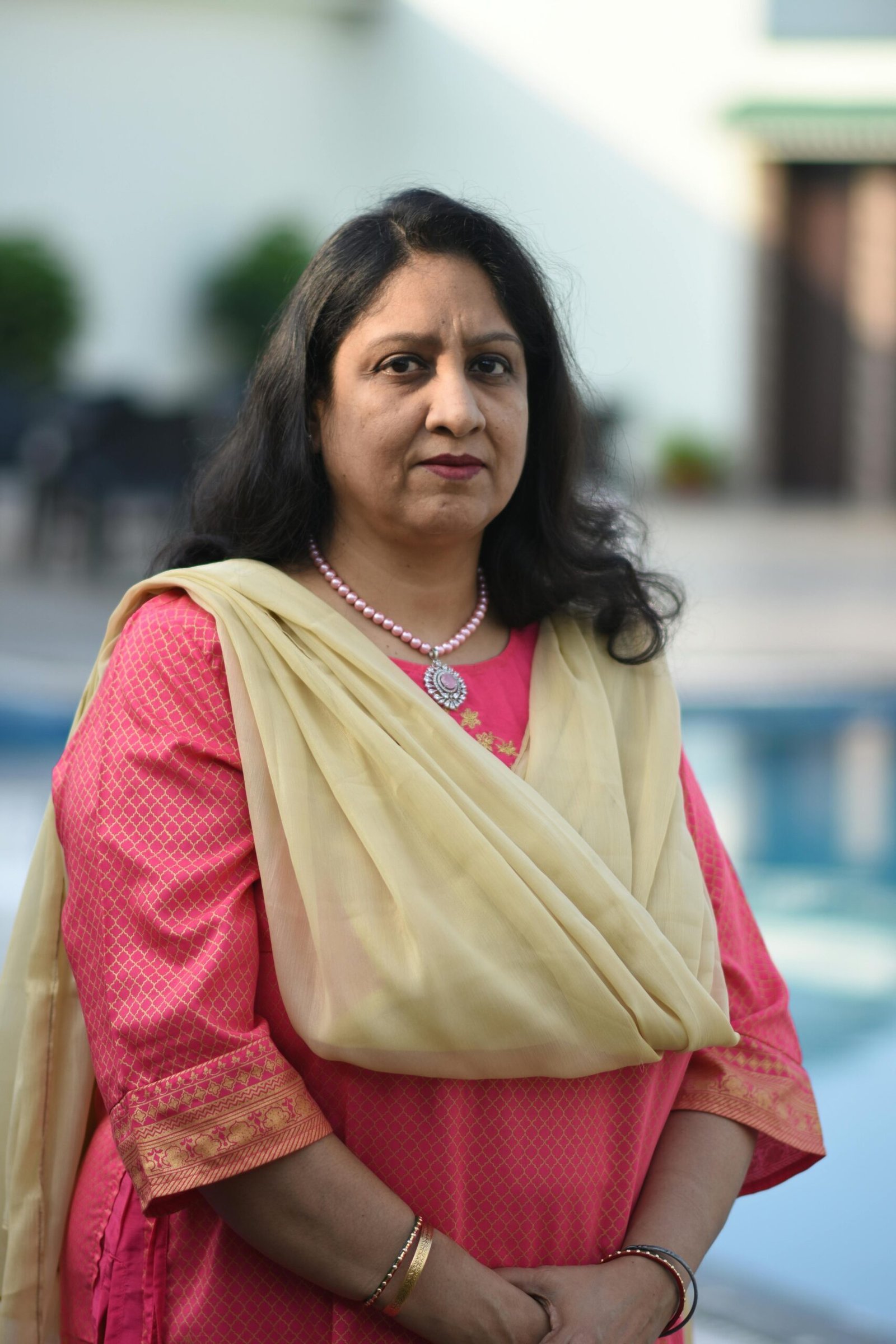 Portrait of a woman in traditional Indian clothing by a poolside in Ballavpur, India.